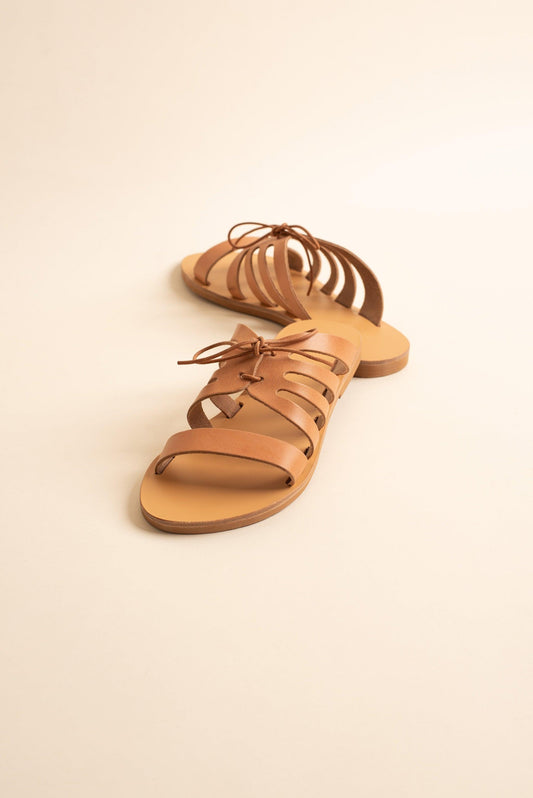 Chloe comfortable flats in tan against a beige background. They are a pair of bow sandals flat.