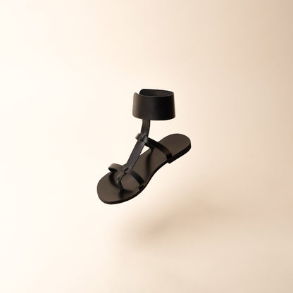 Black leather flats on a beige background