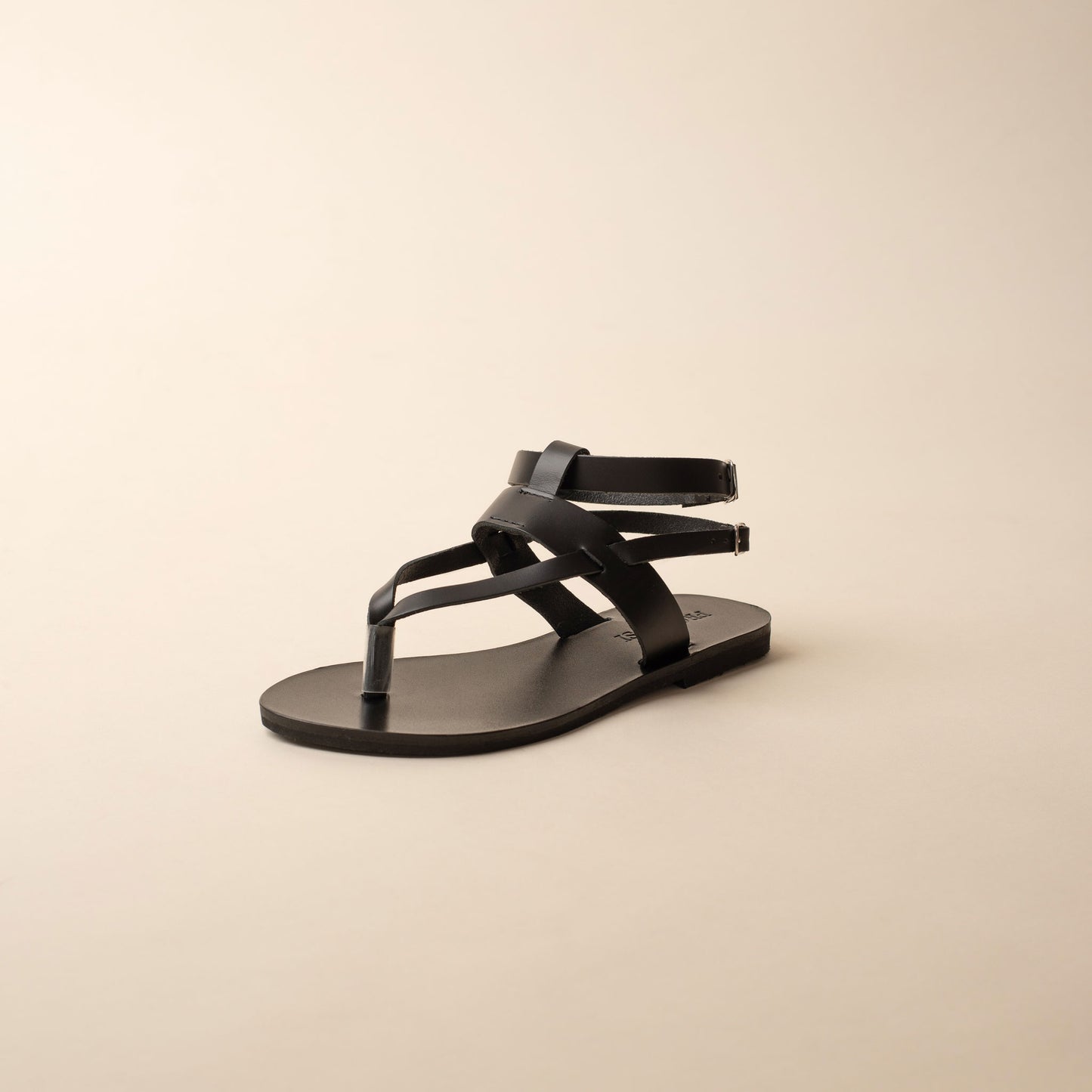 Black double strap sandal for women on a beige background
