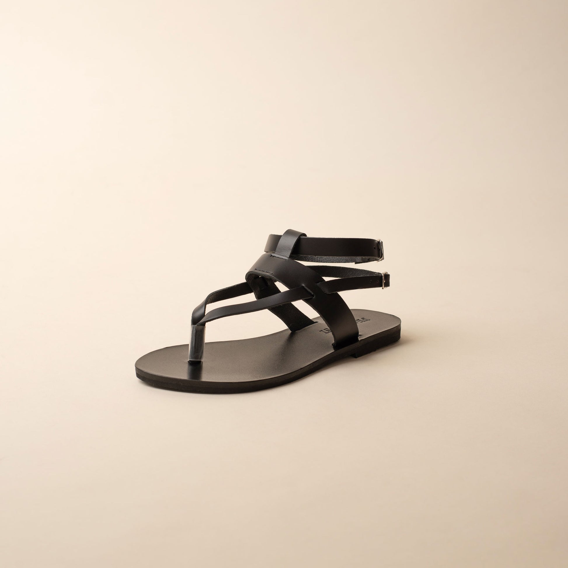 Black double strap sandal for women on a beige background